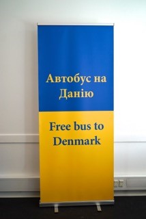 A sign in Ukraine colors and language, leading refugees to free busses to Denmark (C) Danish Immigration Museum